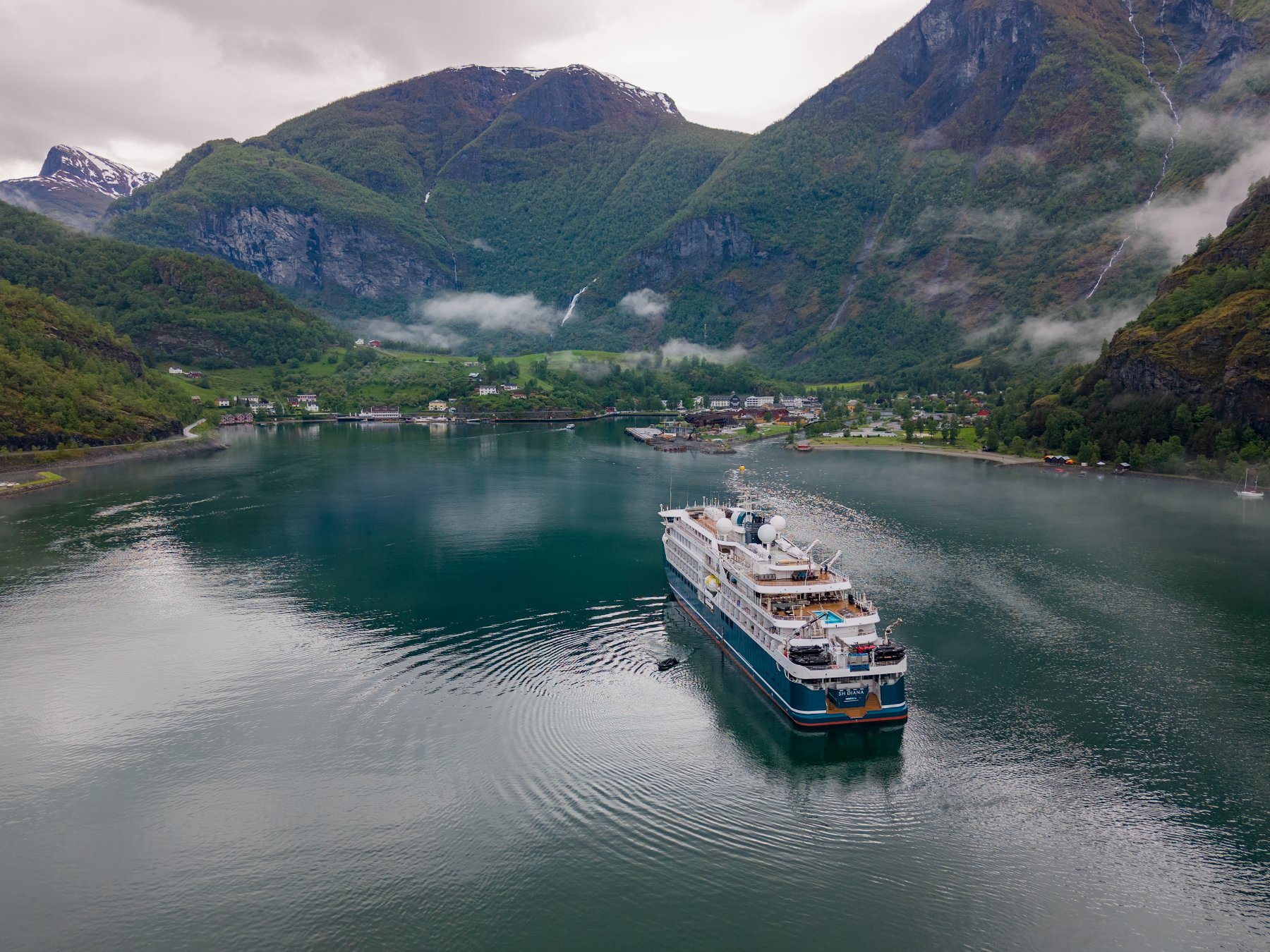 SH Diana navegando em fiorde norueguês cercado de montanhas verdes