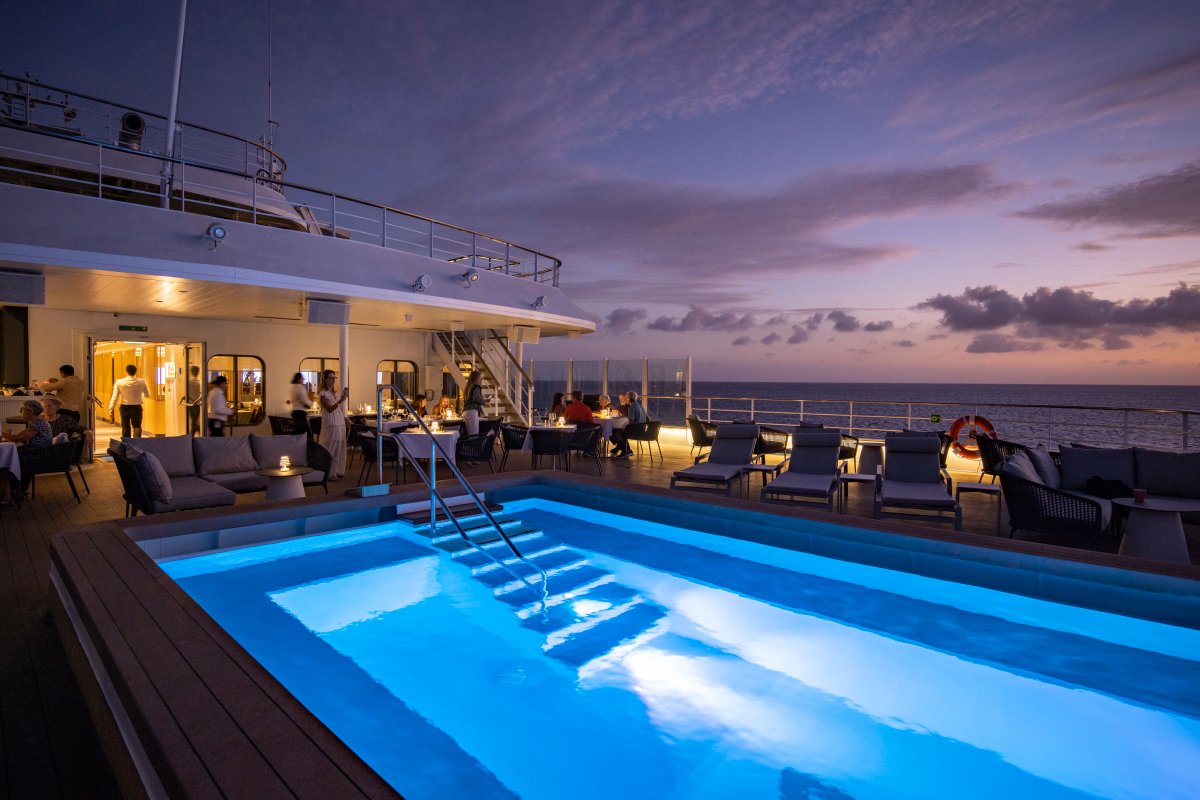 Illuminated pool deck of a Swan Hellenic ship at dusk